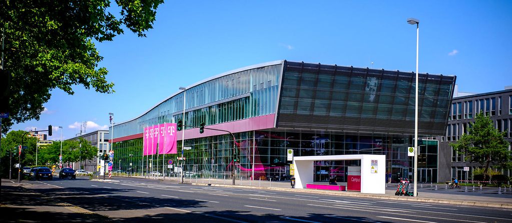 A Telekom building with Telekom flags and trees in front of it