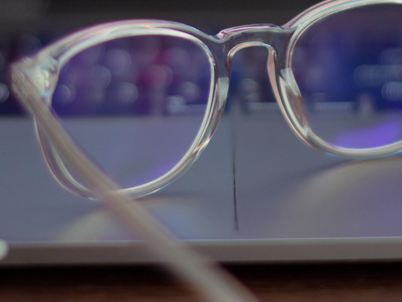 Eine Brille liegt auf der Tastatur eines offenen Laptops